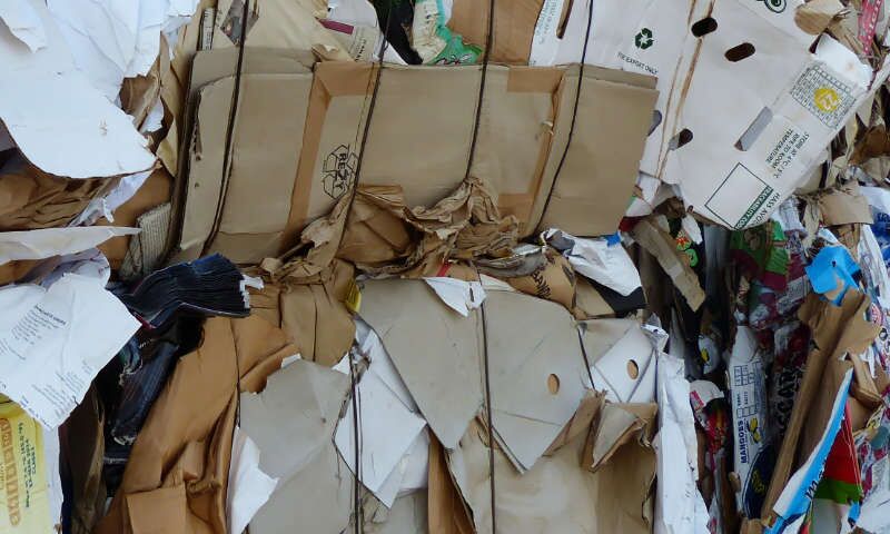 Kartons und Pappe-Behälter aus Supermarkt und Einzelhandel wurden von einer Papier-Presse zu Altpapier-Bündel gepresst und auf einander gestapelt. Dixi-Ballenpresse hat gegenüber Presscontainern den Vorteil eines geringen Platzbedarfs.