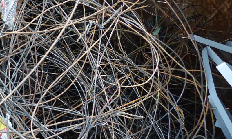 Zusammengeworfene, verknotete verrostete Stalldrähte in einem Sammel-Container stehen für Ankauf und Verkauf von Stock Lots in Frankfurt, Rhein-Main und weltweit. Verpackungsgebinde aus Metall.