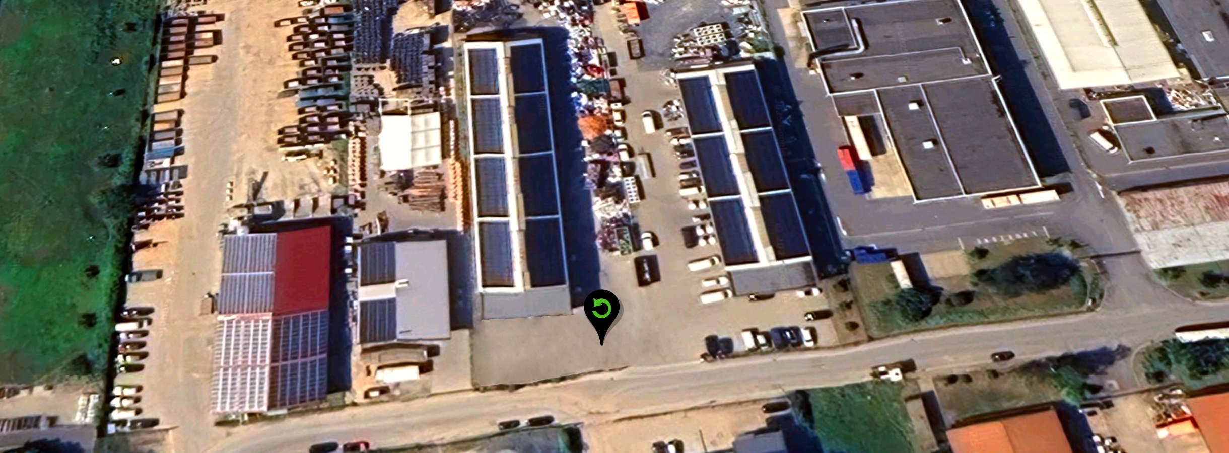 Sateliten-Aufnahme einer langen Produktionshalle für Kunststoff-Recycling der Xpress Plastics GmbH. Das Dach ist mit Solarmodulen abgedeckt. Auf dem Gelände des Wertstoffhofs befinden sich unterschiedliche Container, Kunststoff- und Plastikabfall.